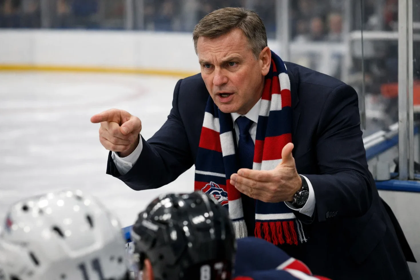 Eishockeytrainer gibt Anweisungen an der Bande während eines Spiels